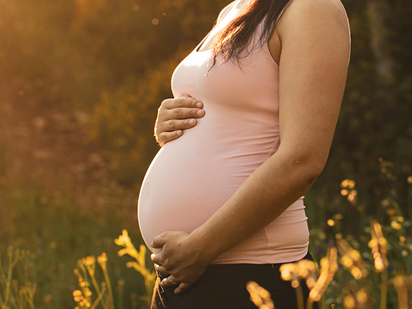 Schwangere Frau hält sich den Babybauch