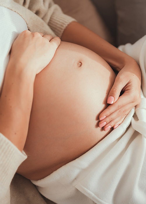 Schwangere Frau hält ihren Bauch